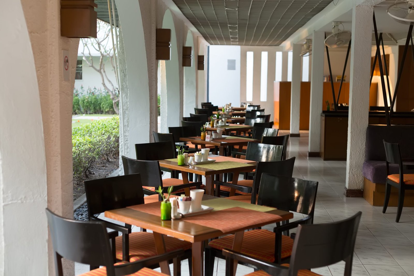 Empty restaurant with set tables with columns.